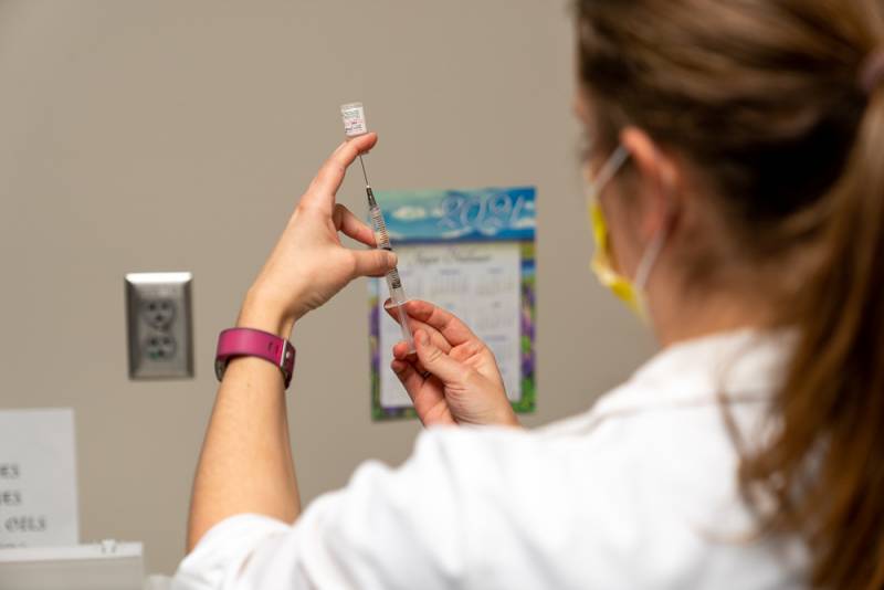 Abby Brown, Pharmacist prepares to administer the first vaccine